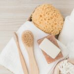 spa-products-with-brushes-loofah-wooden-background_23-2147926989